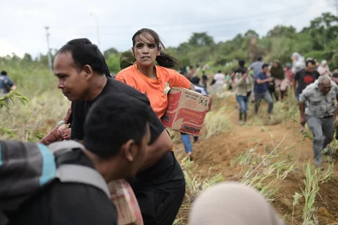 Warga saat mendapatkan  bantuan kemanusiaan di daerah terdampak banjir di Aceh Tengah, Indonesia, Sabtu (06/12/2025).