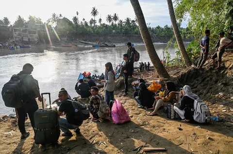 Warga terdampak banjir menunggu perahu untuk menyeberangi Sungai Peusangan di Kuta Blang, Kabupaten Bireuen, Provinsi Aceh, Selasa (09/12/2025).