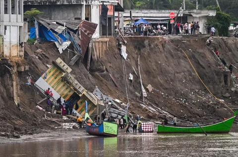 Warga saat akan menyeberangi Sungai Peusangan dengan perahu nelayan di Kuta Blang, Kabupaten Bireuen, Provinsi Aceh, Selasa (09/12/2025).