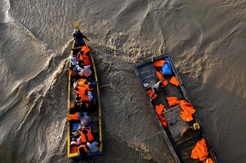 Warga menyeberangi Sungai Peusangan dengan perahu nelayan di Kuta Blang, Kabupaten Bireuen, Provinsi Aceh, Selasa (09/12/2025).