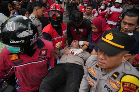 Polisi dan petugas medis mengevakuasi jenasah korban kebakaran kebakaran di gedung perkantoran Terra Drone di Jalan Letjen Suprapto, Cempaka Baru, Kemayoran, Jakarta Pusat Selasa (09/12/2025)..
