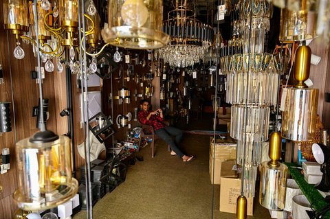 Seorang pria menunggu pelanggan di toko lampu yang redup selama pemadaman listrik nasional gara-gara monyet di Galle, Sri Lanka, pada 9 Februari 2025.