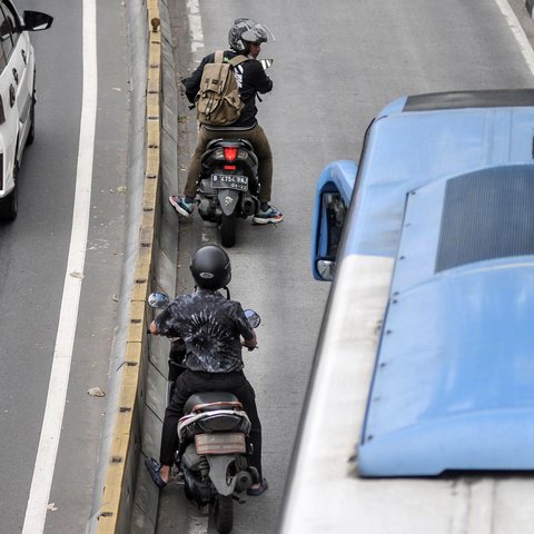 Pengendara sepeda motor menepi saat Bus Transjakarta melintas di jalur Bus Transjakarta di Jalan Kramat Raya, Kecamatan Senen, Jakarta, Kamis (21/7/2022). Razia digelar untuk menindak para pengendara yang tidak disiplin demi menghindari kemacetan serta mencegah terjadi kecelakaan di jalur Bus Transjakarta. (merdeka.com/Iqbal S. Nugroho)