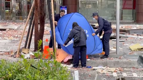 Petugas layanan darurat menutupi jenazah salah satu korban di antara kerusakan akibat ledakan gas di pusat perbelanjaan Taichung di Taichung, Taiwan, 13 Februari 2025.