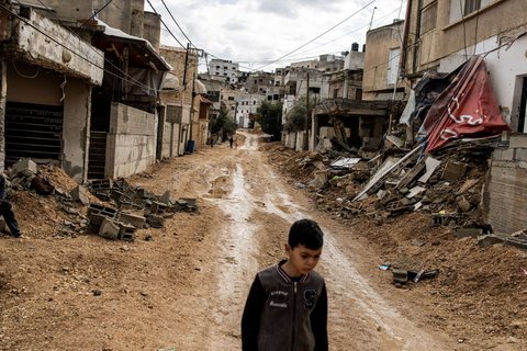 Seorang bocah Palestina melewati jalan yang dihancurkan oleh pasukan Israel selama operasi militer besar-besaran di Kota Jenin, wilayah Tepi Barat yang diduduki Israel, pada 13 Februari 2025.
