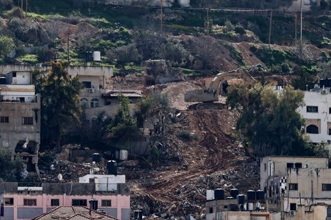 Sebuah ekskavator dan buldoser bekerja menghancurkan rumah-rumah saat pasukan Israel melancarkan operasi militer besar-besaran di Kota Jenin, wilayah Tepi Barat yang diduduki Israel, pada 13 Februari 2025.