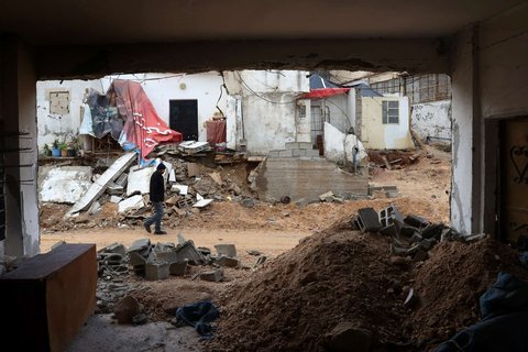 Seorang warga Palestina melewati bangunan dihancurkan oleh pasukan Israel selama operasi militer besar-besaran di Kota Jenin, wilayah Tepi Barat yang diduduki Israel, pada 13 Februari 2025.