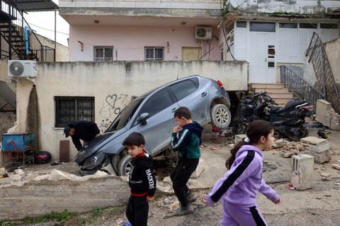 Sejumlah anak Palestina berjalan melewati mobil yang rusak setelah pasukan Israel melancarkan operasi militer besar-besaran di Kota Jenin, wilayah Tepi Barat yang diduduki Israel, pada 13 Februari 2025.