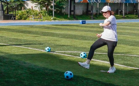 Ketua Forum Pemred Retno Pinasti menendang bola saat membuka Olahraga Bareng, Forum Pemred dan FH BUMN di Brilian Fatmawati, Jakarta Selatan, Sabtu (15/02/2025).