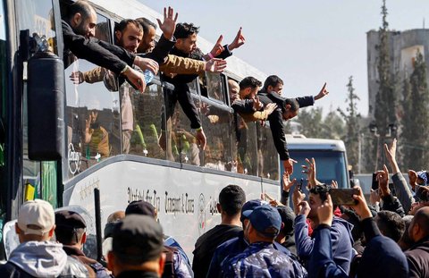 Tahanan Palestina bersorak gembira dari balik jendela bus di Khan Younis, Jalur Gaza Selatan, Palestina, (15/02/2025).