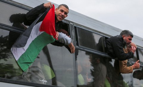 Tahanan Palestina bersorak gembira dari balik jendela bus di Khan Younis, Jalur Gaza Selatan, Palestina, (15/02/2025).