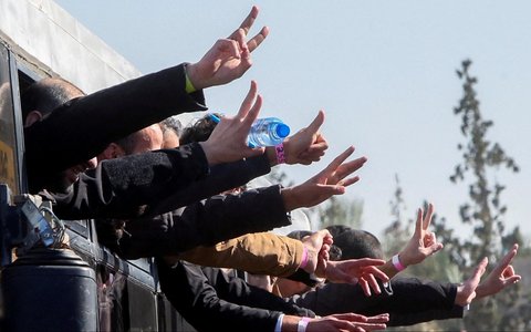 Tahanan Palestina bersorak gembira dari balik jendela bus di Khan Younis, Jalur Gaza Selatan, Palestina, (15/02/2025).