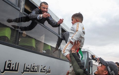 Tahanan Palestina bersorak gembira dari balik jendela bus di Khan Younis, Jalur Gaza Selatan, Palestina, (15/02/2025).