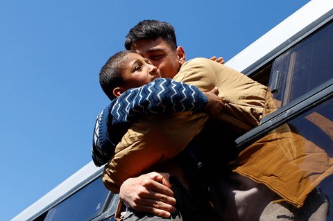 Tahanan Palestina memeluk anaknya dari balik jendela bus di Khan Younis, Jalur Gaza Selatan, Palestina, (15/02/2025).