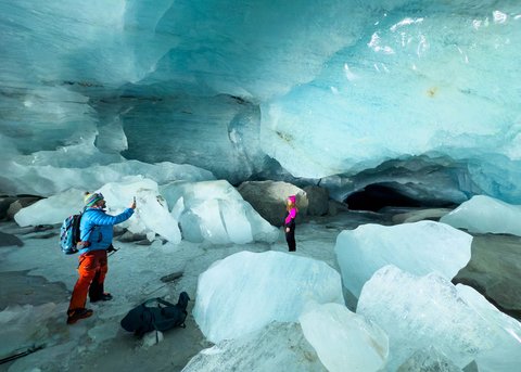 Pendaki beraktifitas dalam gua es yang terbentuk oleh air saat musim panas pada gletser Morteratsch yang  mencair akibat perubahan iklim di Pegunungan Alpen, Swiss, Sabtu (21/02/ 2025) waktu setempat.