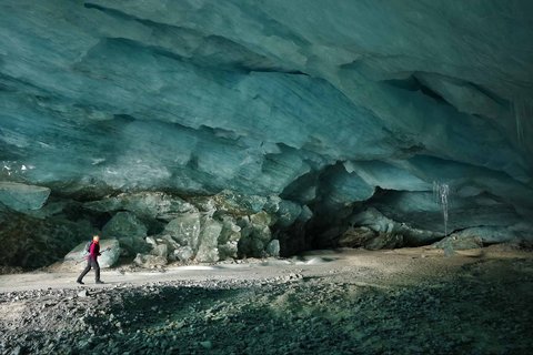 Pendaki berjalan dalam gua es yang terbentuk oleh air saat musim panas pada gletser Morteratsch yang  mencair akibat perubahan iklim di Pegunungan Alpen, Swiss, Sabtu (21/02/ 2025) waktu setempat.