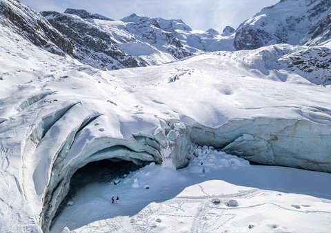 Pemandangan drone menunjukkan orang-orang berdiri di dekat pintu masuk gua di Pontresina, Swiss, Sabtu (21/02/ 2025) waktu setempat.