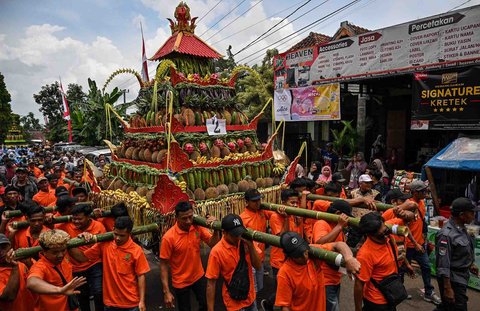 Warga mengarak durian dan buah-buahan lainnya saat festival durian "Kenduren Wonosalam" di desa Wonosalam, Jombang,  Jawa Timur, (23/ 02/ 2025).