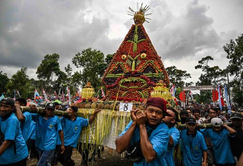 Warga mengarak durian dan buah-buahan lainnya saat festival durian "Kenduren Wonosalam" di desa Wonosalam, Jombang,  Jawa Timur, (23/ 02/ 2025).