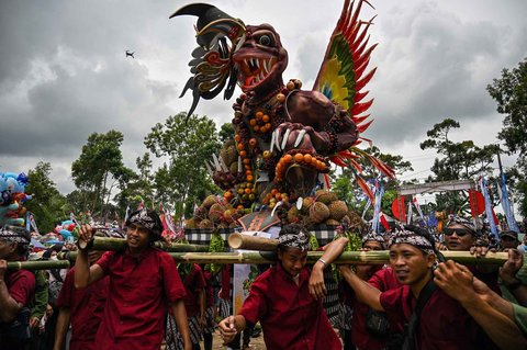 Warga mengarak durian dan buah-buahan lainnya saat festival durian "Kenduren Wonosalam" di desa Wonosalam, Jombang,  Jawa Timur, (23/ 02/ 2025).