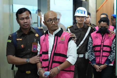 Direktur Optimasi Feedstok dan Produk PT Kilang Pertamina Internasional, Sani Dinar Saifuddin mengenakan rompi tahanan dengan tangan terborgol setelah ditetapkan sebagai tersangka kasus dugaan korupsi dalam tata kelola minyak mentah dan produk kilang pada PT Pertamina Subholding dan Kontraktor Kontrak Kerja Sama (KKKS) tahun 2018-2023 di Kejaksaan Agung, Jakarta, Selasa (25/2/2025).