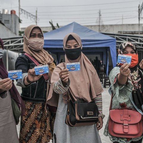 Orangtua dari anak penerima saat menunjukkan KJP yang baru diterima di kawasan Matraman, Jakarta, Selasa (24/11/2020). Penyaluran KJP plus tahap kedua ini menggunakan data baru berdasarkan pembaruan berkas warga penerima yang rampung pada bulan Oktober lalu. (merdeka.com/Iqbal S. Nugroho)