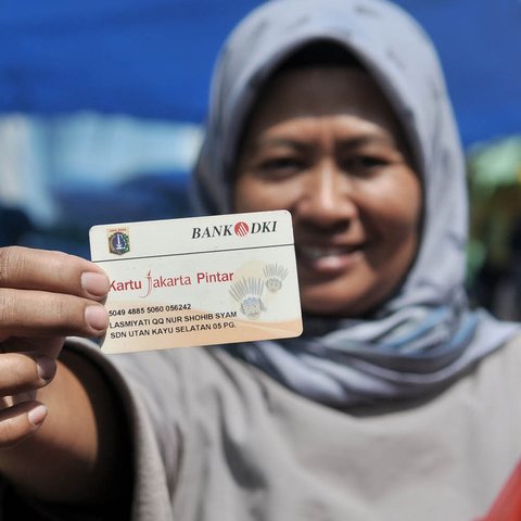 Warga menunjukkan KJP dan kebutuhan pokok yang dibeli dari Program Pangan Murah di RPTRA Utakara Beriman, Jakarta, Kamis (20/6/2019). Program tersebut juga bertujuan meningkatkan gizi warga pemegang Kartu Lansia Jakarta, PPSU, PHL, PJLP, UMP, serta penghuni Rusun Pemda. (merdeka.com/Iqbal S Nugroho)