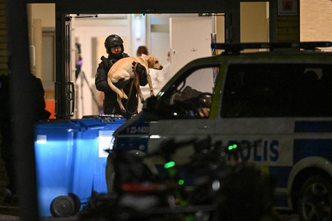 Seorang polisi membawa seekor anjing di Kampus Risbergska di Orebro, Swedia, (04/02/2025).