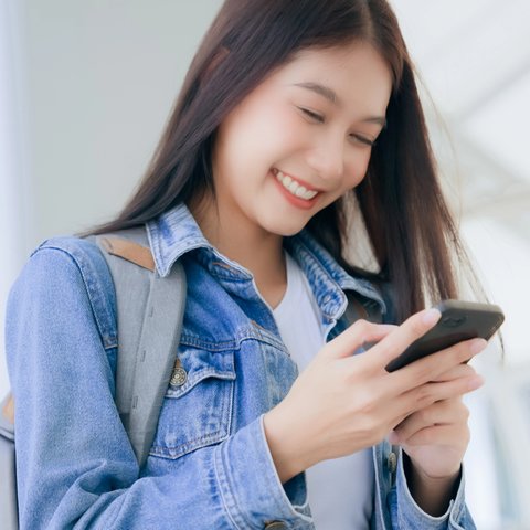 Seorang wanita memakai ponsel.