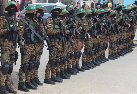 Militan Hamas Palestina berjaga saat proses pembebasan sandera di Deir Al-Balah di Jalur Gaza tengah, Sabtu (08/02/2025)