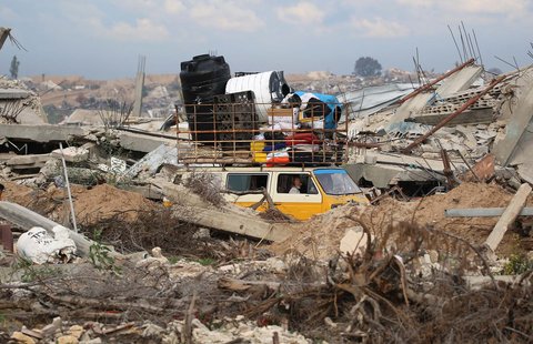 Warga Palestina dengan kendaraan  berjalan melewati Koridor Netzarim, dekat Kota Gaza, Minggu (09/02/2025).