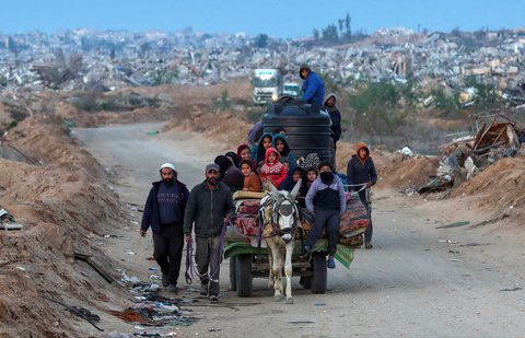 Warga Palestina berjalan melewati Koridor Netzarim, dekat Kota Gaza, Minggu (09/02/2025).