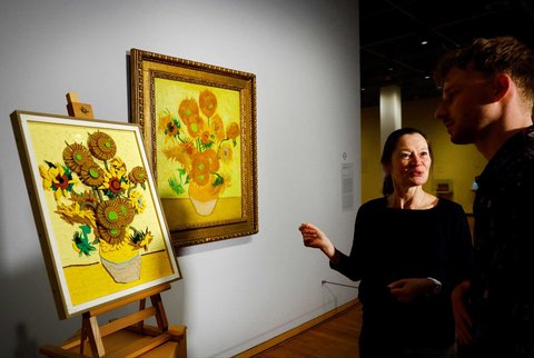 Kurator Museum Van Gogh Nienke Bakker dan Desainer Produk LEGO Stijn Oom berbicara di depan lukisan Bunga Matahari Van Gogh versi bata LEGO disamping versi asli lukisan yang dipajang di Museum Van Gogh Belanda di Amsterdam, Belanda, (28/02/2025) waktu setempat.
