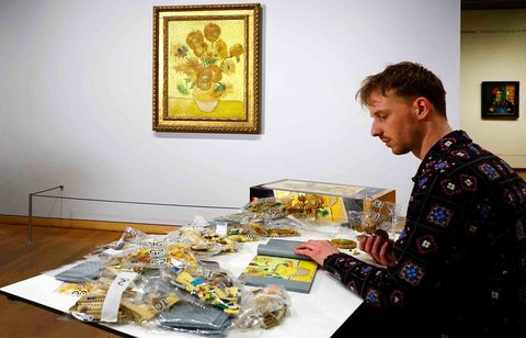 Desainer Produk LEGO Stijn Oom merakit Lego  di depan lukisan Bunga Matahari Van Gogh di Museum Van Gogh Belanda di Amsterdam, Belanda, (28/02/2025) waktu setempat.
