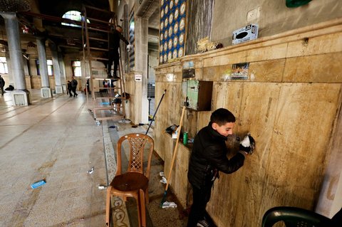 Sejumlah warga membersihkan abu yang menempel pada Masjid Al-Nasser sehari setelah diserbu dan dibakar tentara Israel di Nablus, Tepi Barat, Palestina, pada 8 Maret 2025.