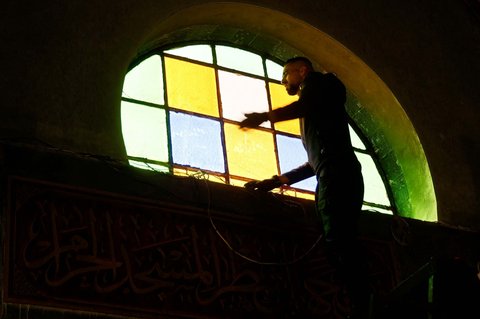 Warga membersihkan abu yang menempel pada Masjid Al-Nasser sehari setelah diserbu dan dibakar tentara Israel di Nablus, Tepi Barat, Palestina, pada 8 Maret 2025.