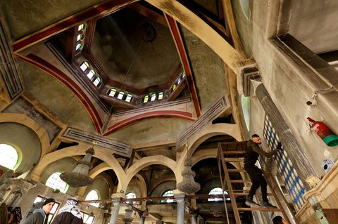 Warga membersihkan abu yang menempel pada Masjid Al-Nasser sehari setelah diserbu dan dibakar tentara Israel di Nablus, Tepi Barat, Palestina, pada 8 Maret 2025.