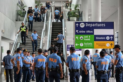 Puluhan anggota polisi diterjunkan untuk melakukan penjagaan di terminal kedatangan Bandara Internasional Ninoy Aquino, Pasay, Metro Manila, Filipina, ketika mantan Presiden Filipina Rodrigo Duterte ditangkap, pada 11 Maret 2025.