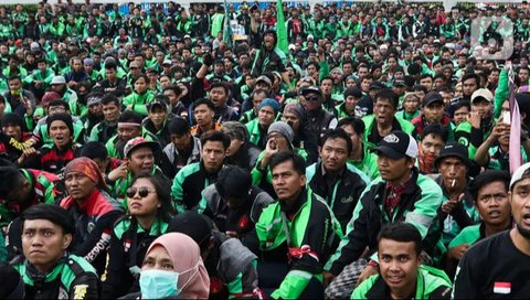 Pengemudi ojek online (ojol) memenuhi bahu jalan saat menunggu penumpang di kawasan Cililitan, Jakarta, Rabu (16/9/2020). Pemprov DKI Jakarta telah melarang ojol dan ojek pangkalan berkumpul