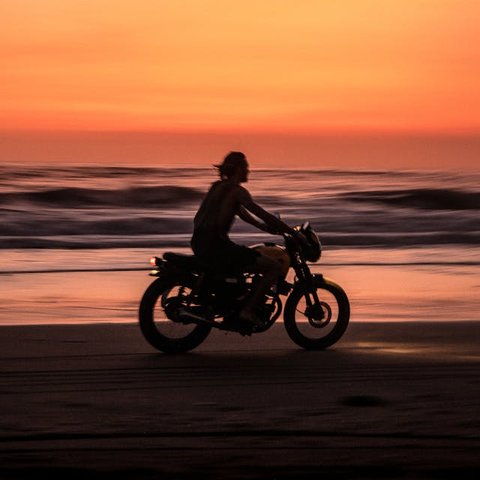 Ilustrasi Pria Mengendarai Motor di Pinggir Pantai