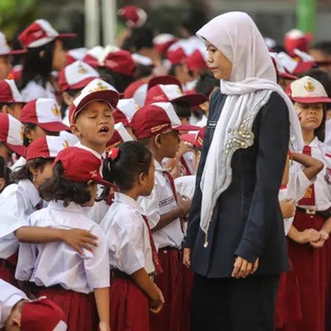 Guru mengatur para murid sebelum upacara di SD Pasar Baru 05, Jakarta, Senin (27/7/2015). Usai libur panjang Idul Fitri para siswa kembali beraktivitas mengikuti pelajaran di sekolah untuk ta