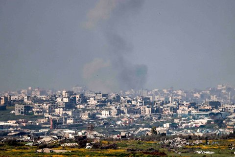 Asap mengepul dari  bangunan-bangunan yang hancur  di Jalur Gaza utara, Palestina, Selasa (18/03/2025).