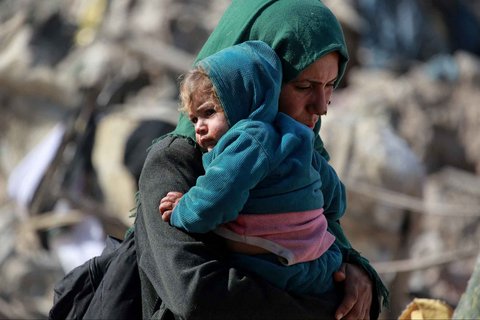 Seorang wanita Palestina menggendong bayi di wilayah timur Gaza,  Palestina, Selasa (18/03/2025).