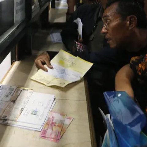 Warga mengisi formulir untuk membayar pajak kendaraan bermotor di samsat keliling di car free day, Jakarta, Minggu (27/8). Perpanjangan STNK tanpa BPKB hanya berlaku di gerai Samsat Keliling
