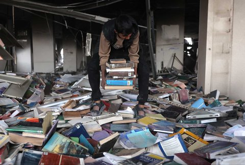 Warga yang mengungsi membakar kertas buku yang dikumpulkan dari Universitas Islam yang hancur untuk memasak makanan di Kota Gaza Palestina, (21/03/2025) waktu setempat.