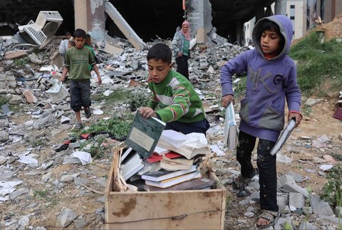 Warga yang mengungsi membakar kertas buku yang dikumpulkan dari Universitas Islam yang hancur untuk memasak makanan di Kota Gaza Palestina, (21/03/2025) waktu setempat.