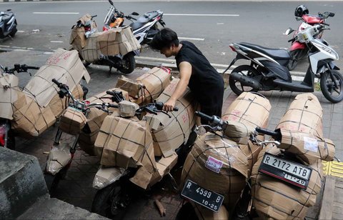 Kesibukan pekerja  di salah satu jasa pengiriman logistik di kawasan Pasar Senen, Jakarta, Minggu (23/03/2025).