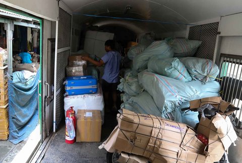 Kesibukan pekerja  di salah satu jasa pengiriman logistik di kawasan Pasar Senen, Jakarta, Minggu (23/03/2025).