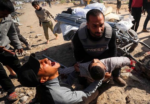 Warga memegang jenazah jurnalis Hossam Shabat, yang tewas dalam serangan Israel, di Jalur Gaza Utara (24/03/2025).