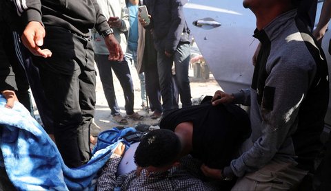 Warga memegang jenazah jurnalis Hossam Shabat, yang tewas dalam serangan Israel, di Jalur Gaza Utara (24/03/2025).